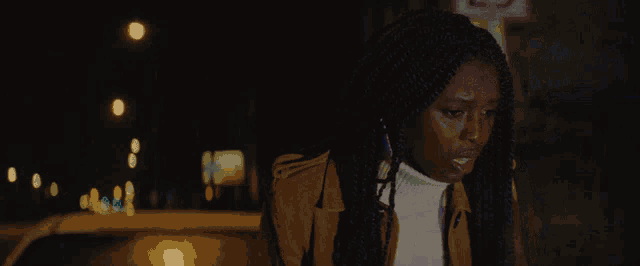 a woman with braids is standing in front of a sign that says no parking