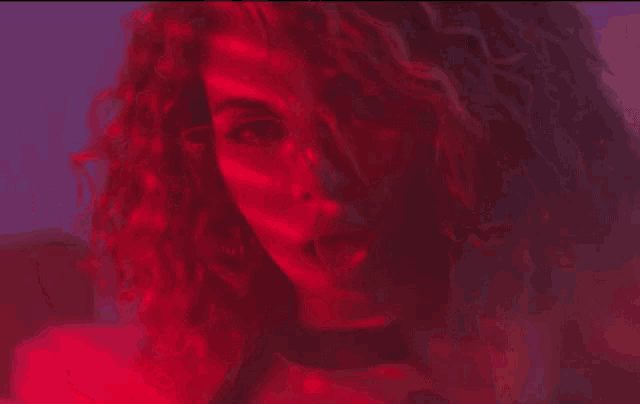a close up of a person 's face with red lights behind it .