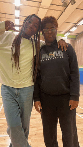 a woman wearing a black puma sportswear sweatshirt stands next to another woman