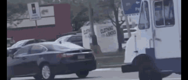 a black car is driving down the street next to a white truck .