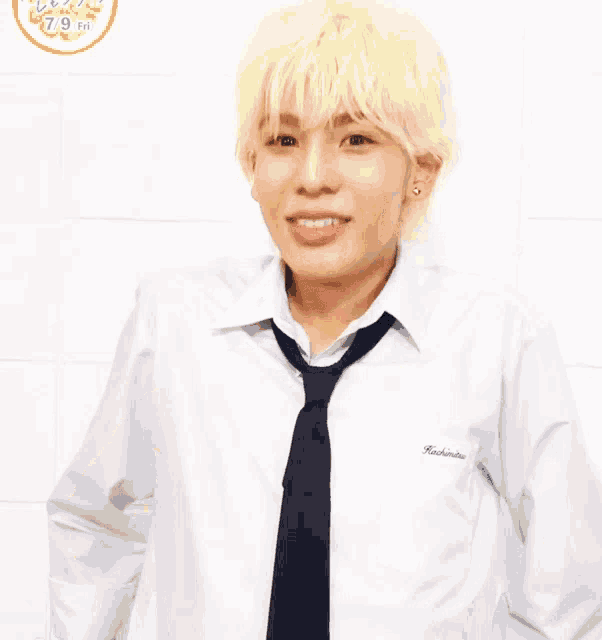 a man in a white shirt and tie is holding a box with a yellow ribbon around it