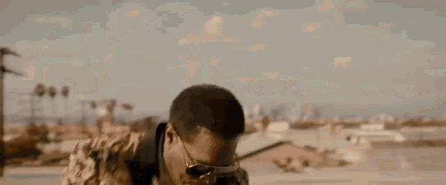 a man is giving the middle finger while standing on top of a roof .