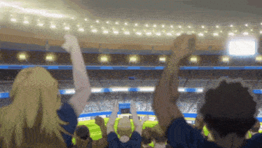 a crowd of people in a stadium with their hands in the air