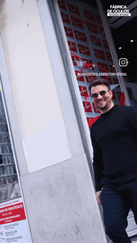 a man standing in front of a ray-ban store