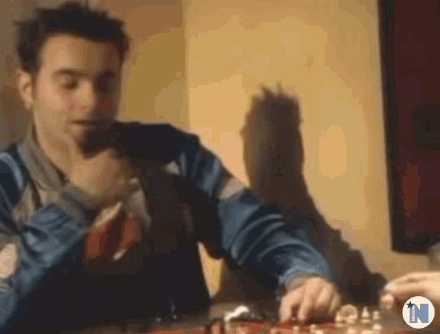 a man in a blue jacket is playing a game of chess