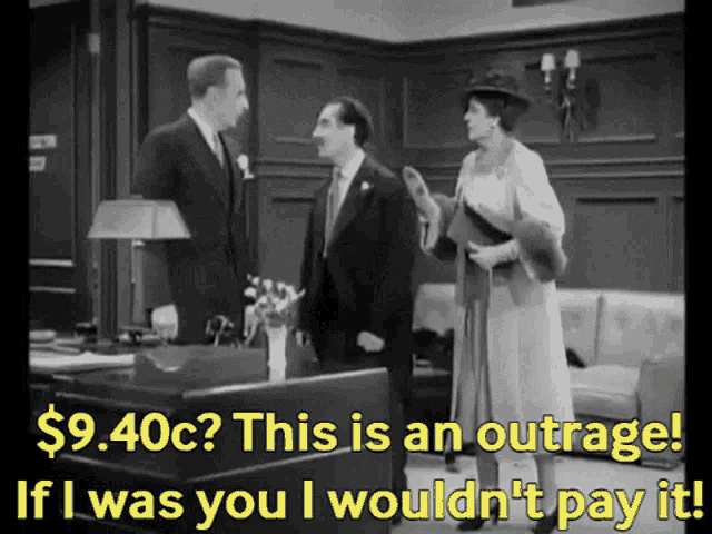 a man in a suit and tie talks to a woman in a hat and says $ 9.40c this is an outrage
