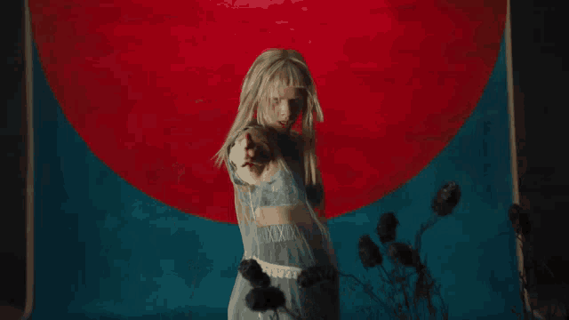 a woman in a white dress is dancing in front of a red circle