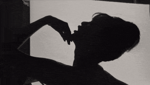 a silhouette of a woman laying on her back with her legs up