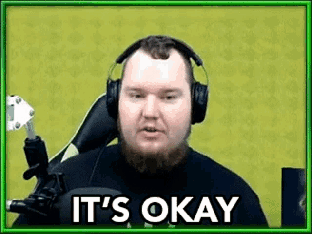 a man wearing headphones is sitting in front of a microphone .