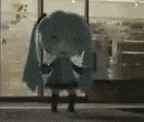 a doll with long blue hair is standing in front of a window .