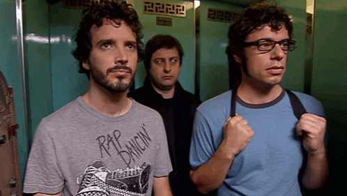 a man wearing a rip dancin t-shirt stands in an elevator