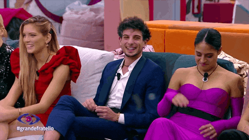a group of people are sitting on a couch with the hashtag grandefratello on the bottom