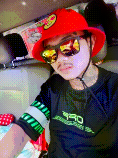 a man wearing a red hat and sunglasses is sitting in the back seat of a car