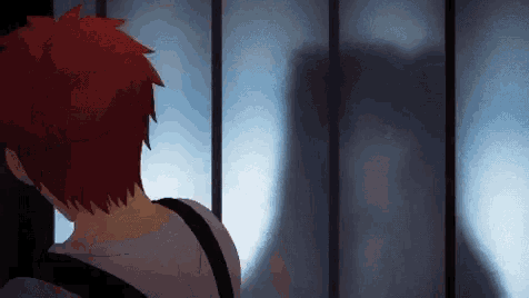 a man with red hair is standing in front of a window with a shadow of a person on it .