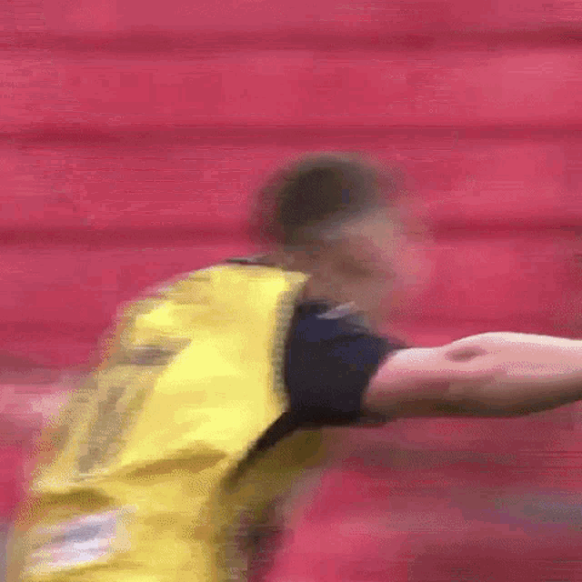 a blurry picture of a soccer player wearing a yellow and black jersey .