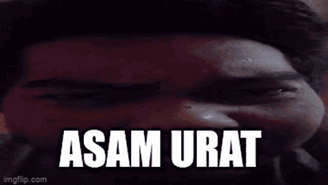 a close up of a man 's face with the words " asam urat " on it