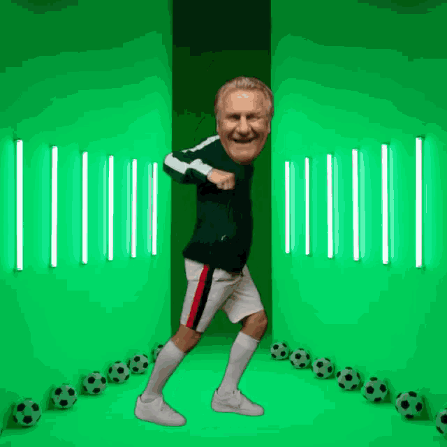 a man is dancing in front of a green wall