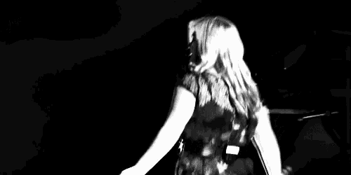 a woman is standing in front of a microphone on a stage .