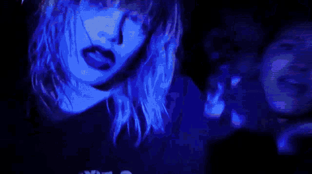 a blurry picture of a crowd of people dancing in a dark room