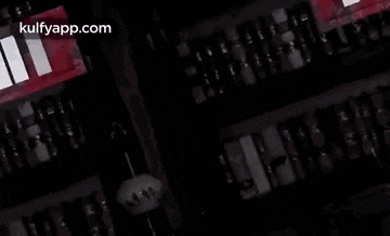 a man with a beard is standing in a dark room with a lightning bolt coming out of his chest .