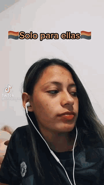 a girl wearing ear buds with the words solo para ellas on the bottom