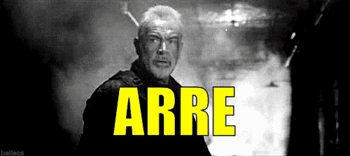 a man with a beard is standing in front of a sign that says arre .