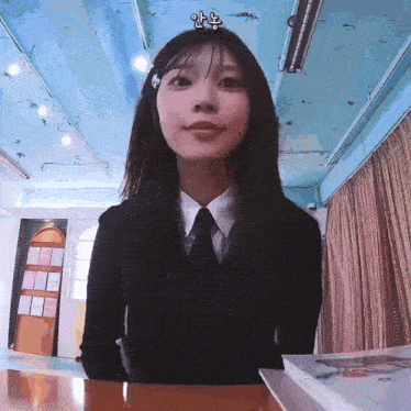 a girl in a suit and tie is sitting at a desk