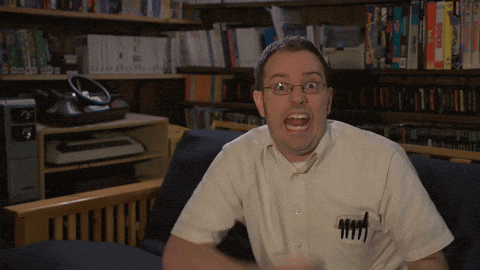 a man sitting on a couch with his mouth open and a pen in his pocket that says 4444