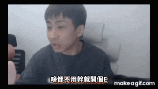 a man in a black shirt is sitting in a chair and talking in a foreign language .