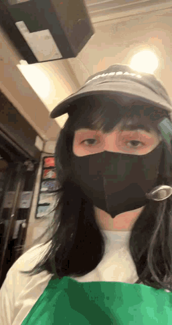 a woman wearing a black mask and a hat with the word subway on it