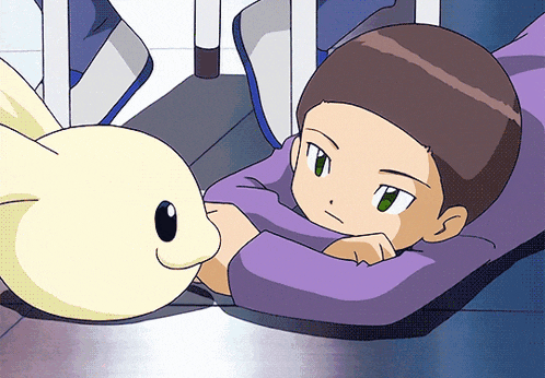 a boy laying on a couch with a stuffed animal on the floor
