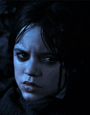 a close up of a woman 's face with a dark background