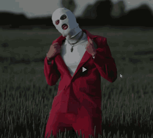 a man wearing a ski mask and a red suit