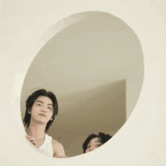 a man is looking at himself in a mirror .