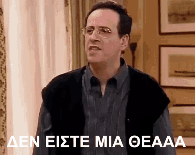 a man wearing glasses and a vest says den eiste mia oeaaa in a living room