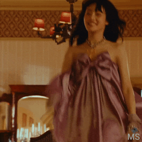 a woman in a purple dress with the word ms on the bottom of her dress