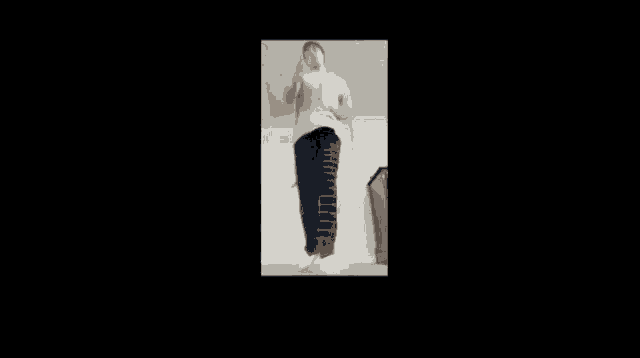 a man in a white shirt and black pants is dancing in a room .