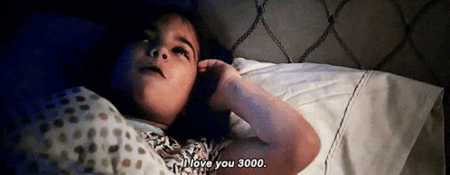 a little girl is laying in bed and says i love you 3000