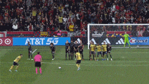 a soccer game is being played in front of a crest sign