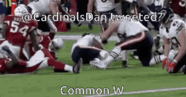 a group of football players are playing a game of football and one of them is laying on the ground .