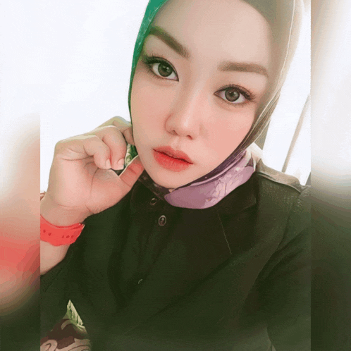 a woman wearing a purple scarf and a black shirt has a red wristband that says ' i love you '