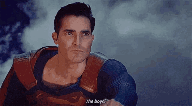 a man in a superman costume is talking to another man in a cloudy sky .