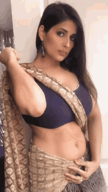 a woman is wearing a saree and a blue top .