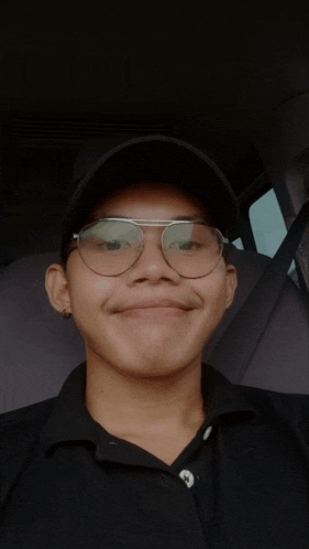 a young man wearing glasses and a black hat makes a funny face