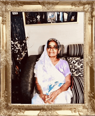 a picture of an elderly woman sitting on a couch with a gold frame