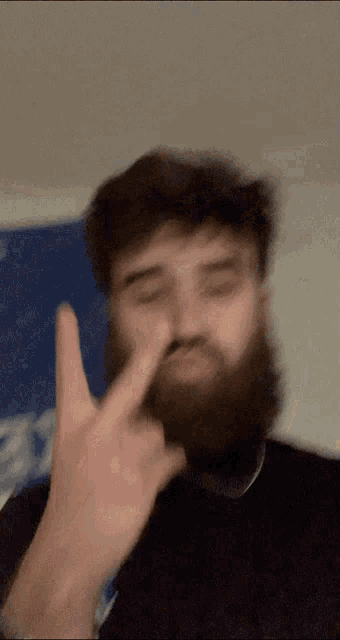 a man with a beard is giving a middle finger