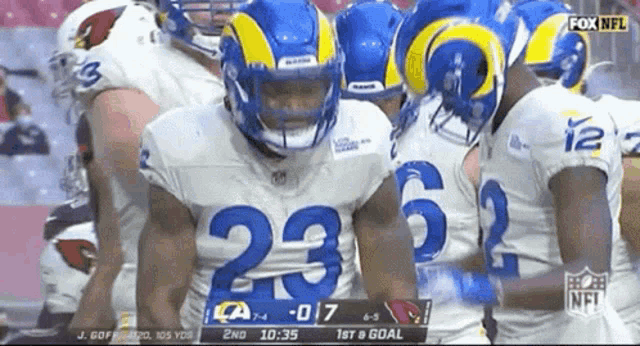 a group of rams football players huddle together