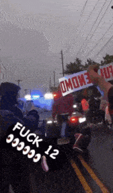 a person is holding a sign that says ' fuck 999912 ' on it
