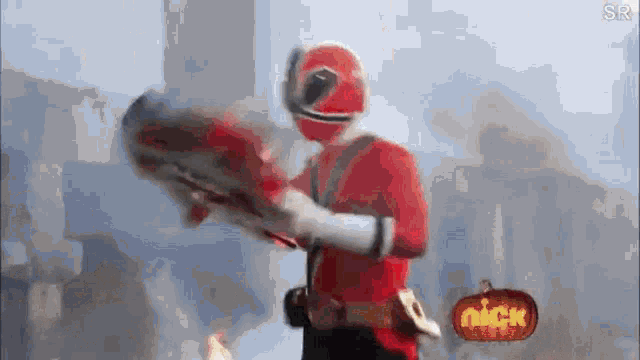 a red power ranger is holding a sword in front of a nick pumpkin .