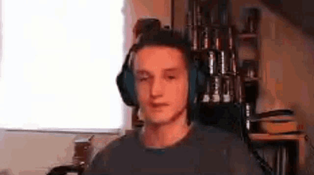 a man wearing headphones is sitting in a chair in front of a computer screen .